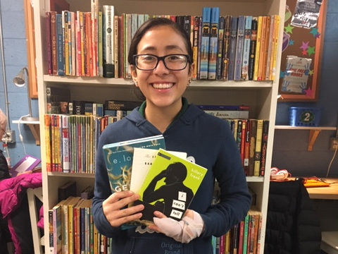 NHR student happily displays books she received in the giveaway.