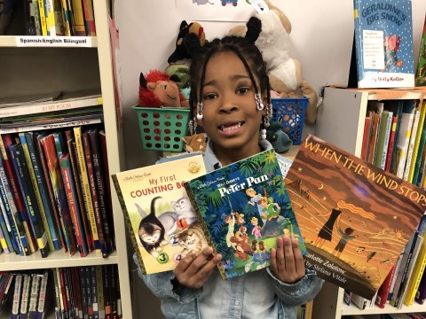 NHR student happily displays a books she received in the giveaway.