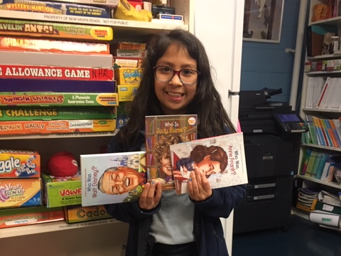 NHR student happily displays books she received in the giveaway.