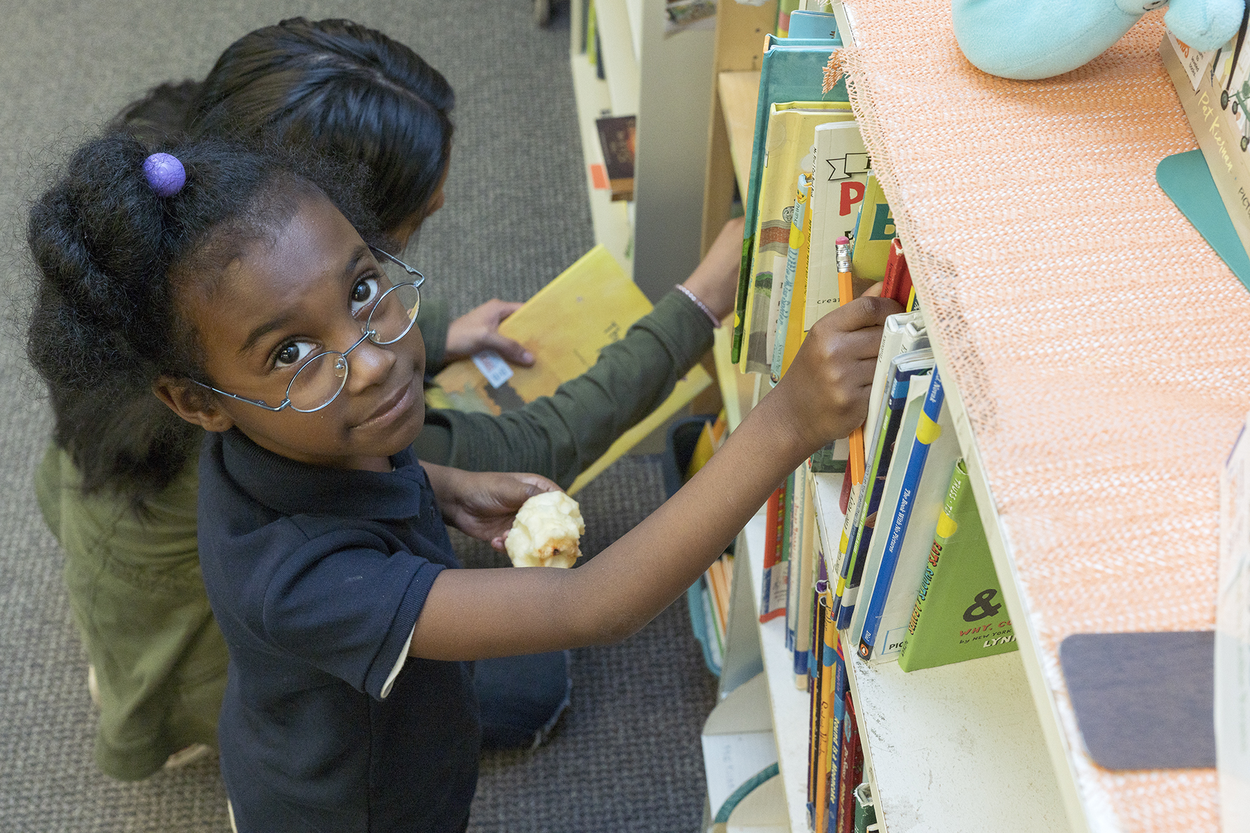 A NHR student chooses a book to read.